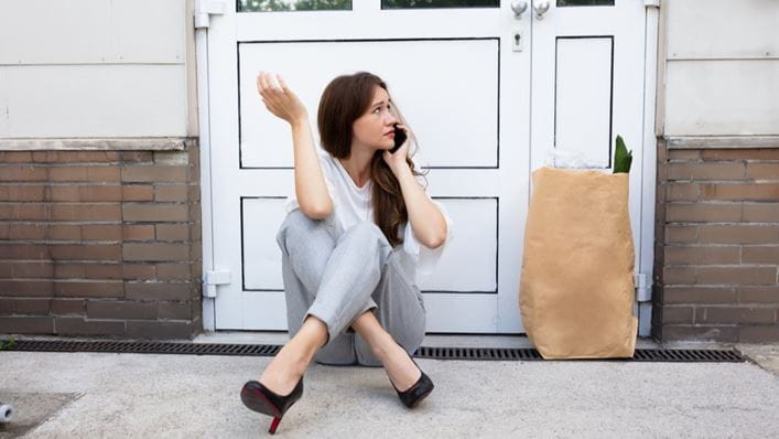 Una mujer llamando a los cerrajeros de HomeServe que no puede abrir la puerta