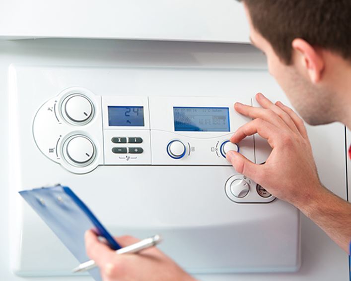 Técnico de gas de HomeServe en la casa de unos clientes recomendando la calefacción más eficiente
