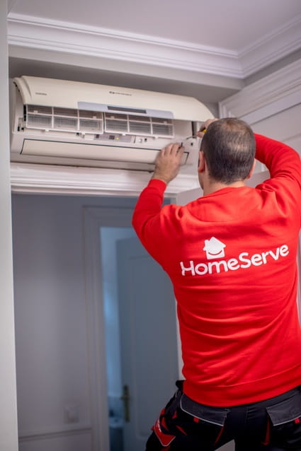 Técnico de reparacion de aire acondicionado de HomeServe arreglando el modo DRY en casa de un cliente