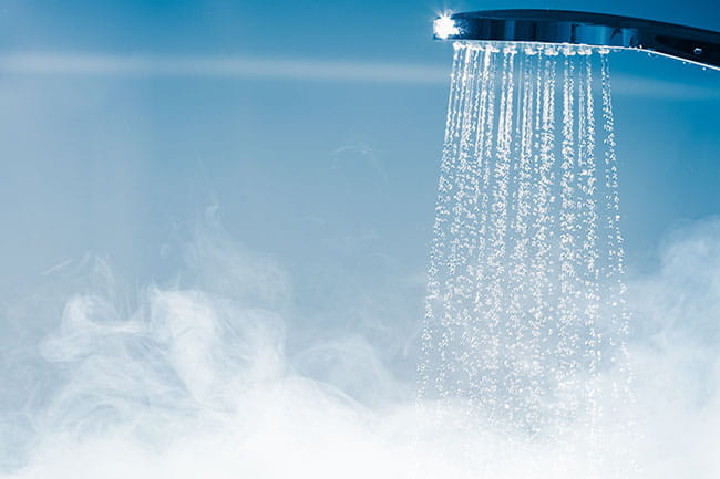 Una ducha expulsando agua caliente de un calentador de agua de gas