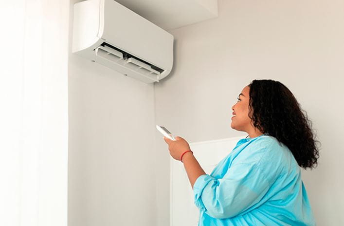 mujer encendiendo aire acondicionado
