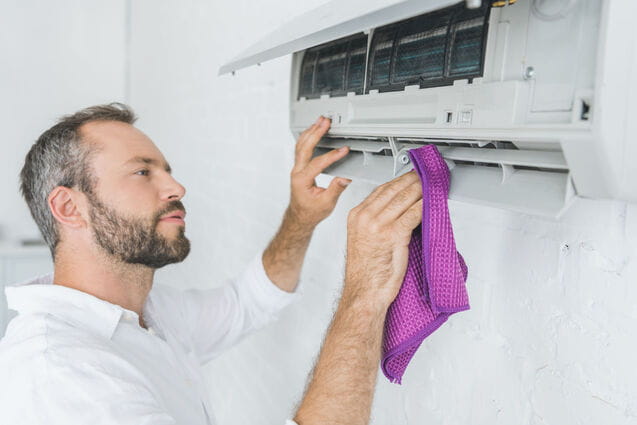 Hombre limpiando un aparato de aire acondicionado